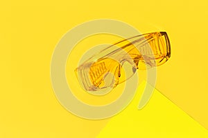Transparent tinted glasses on yellow background. Creative monochrome layout