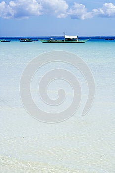 Transparent tropical ocean with white sand on the bottom