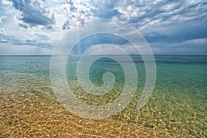 Transparent turquoise sea with dramatic cloudy sky