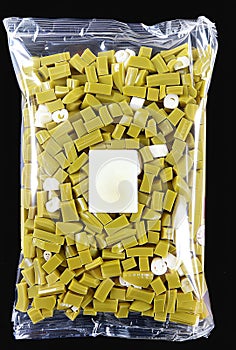 Transparent vacuum-sealed plastic bag full of fresh green wax beans with a white label