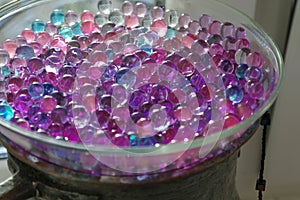 Transparent vase with lilac blue hydrogel balls, bokeh, selective focus