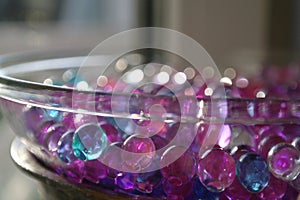 Transparent vase with lilac blue hydrogel balls, bokeh, selective focus