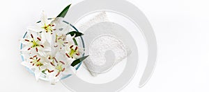 Transparent vase with water and white lilies with a white towel. Isolated on white. Spa concept for cleanliness