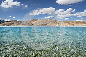 Transparent water and desert hills of high mountain lake