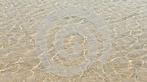 Transparent water ripple, sand waves and sunlight glare. sea floor pattern