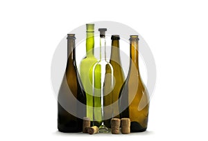Transparent wine bottle, green wine bottle, brown wine bottles and wine corks isolated on white