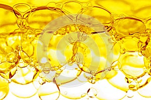 Transparent yellow bubbles in liquid. Cosmetic essence, serum