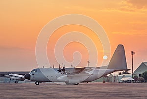 Transport military cargo aircraft parked standby ready to takeoff on sunset time