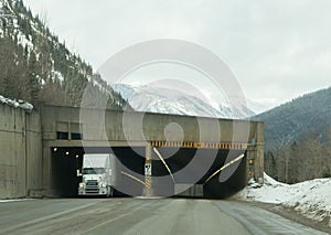 Transport Truck large Rig Driving Through Avalanche Tunnel on Trans Canada Highway