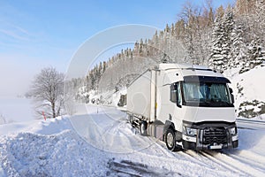 Transport truck stuck in the snow at the cold winter.