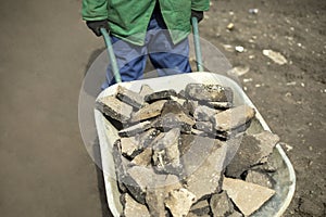 Transportation of broken stone. Worker dismantles block of stones