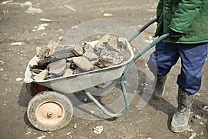 Transportation of broken stone. Worker dismantles block of stones