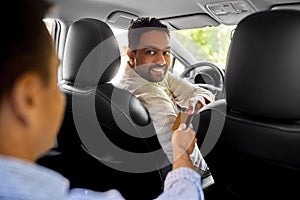 taxi car driver taking credit card from passenger