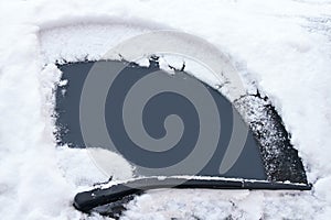 Transportation concept. Car's window has been cleaned from snow by wipers in the winter day.