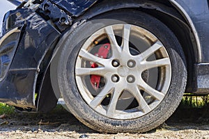 Close up tire after front black car damaged and broken by accident on road