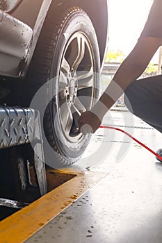 Man technician is inflate put air into the tire . car tyre