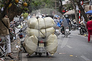 Transportation of goods by motorcycle on the street in old town Hanoi, Vietnam
