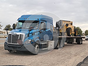 Transportation and Logistics! Big Rig Semi Truck Hauling Construction Vehicle on Flat Bed!