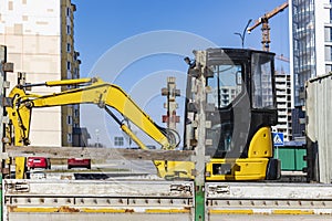 Transportation of a mini excavator to a construction site in a truck. Compact excavator for earthworks