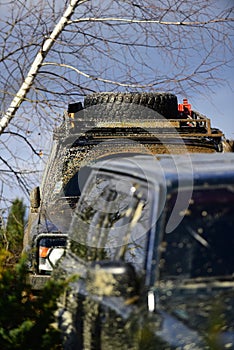 Transportation, powerful motor and driving concept. Two cars covered with mud drops on nature background. Off road