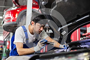 Transportation repair service concept, Repairman auto mechanic using flashlight to check for damage inside engine. man worker