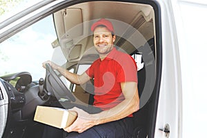 transportation service driver in red uniform sitting in van with box in hand