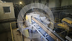 Transportation and sorting of clay on conveyor. Brickworks. Production workshop inside. Manufacturing facility