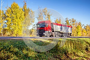 Transportation in special trailers of bulk cargoes of sand and coal on country roads. Automobile cargo transportation, industry.