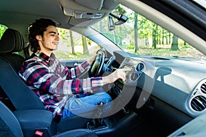 Transportation and vehicle concept. Young man using car audio stereo system