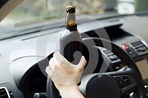 Transportation and vehicle concept - woman drinking alcohol while driving the car