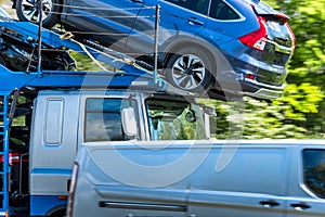 Transporter truck loaded with cars on uk motorway in fast motion