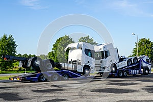 Transporting brand new trucks on specialized truck trailers, delivery to dealers