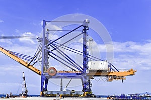 Transporting huge quay crane using self-propelled modular transporter. Moving huge quay crane from ship to harbor.