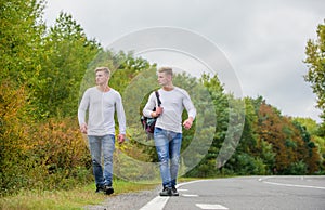Transporting issues. Men backpack walking road. Twins walk along road. Brothers friends nature background. Long way