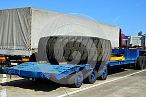 Transporting a large wheel for a mining truck on a truck trailer. The protector of a large rubber wheel.