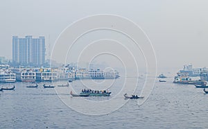 Transporting local people by small boats across the river, Commuter ferryboat in the monsoon, Boat ride in the Buriganga river.