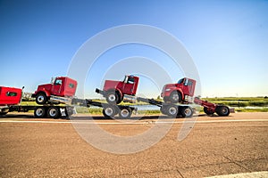 Transporting three new red trucks