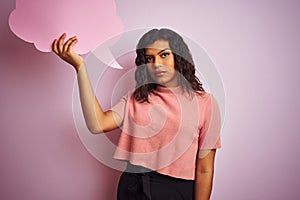 Transsexual transgender woman holding speech cloud bubble over isolated pink background with a confident expression on smart face