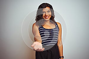 Transsexual transgender woman wearing striped t-shirt over isolated white background smiling cheerful offering palm hand giving