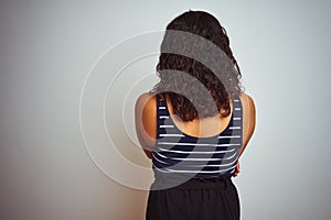 Transsexual transgender woman wearing striped t-shirt over isolated white background standing backwards looking away with crossed