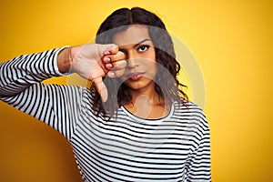 Transsexual transgender woman wearing striped t-shirt over isolated yellow background with angry face, negative sign showing