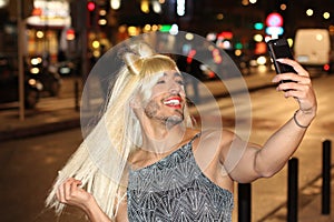 Transvestite taking a selfie outdoors photo