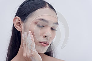 A transwoman removes makeup by washing her face with facial wash for sensitive skin prescribed by dermatologists. Beauty products