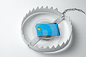 Trap with stack of credit cards. Unsafe credit risk. Gray background.