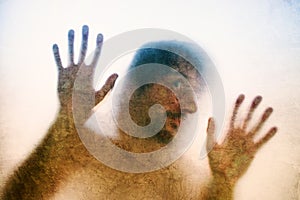 Trapped man, back lit silhouette of hands behind matte glass