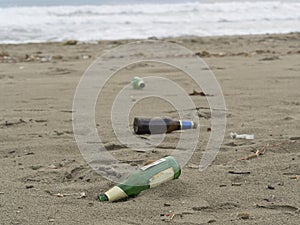 Trash on the beach: beer bottles abandoned on the sand