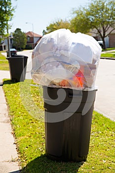 Trash bin dustbin full of garbage on street lawn