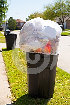 Trash bin dustbin full of garbage on street lawn photo