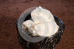 A trash bin full of dirty used baby`s diapers.  Disposable nappies