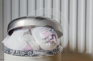 Trash bin full of used diapers. Close up